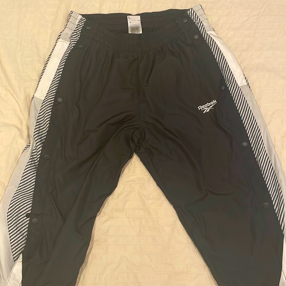 Reebok nylon track pants. Removable buttons on the side